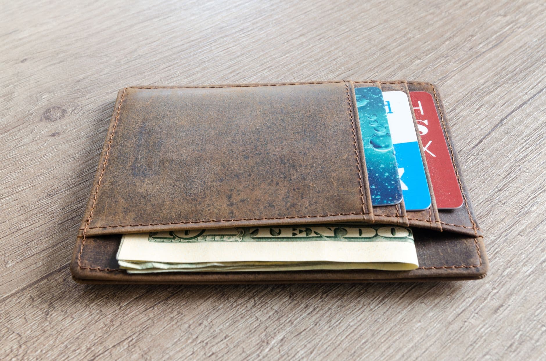 A leather wallet with credit cards and cash tucked inside